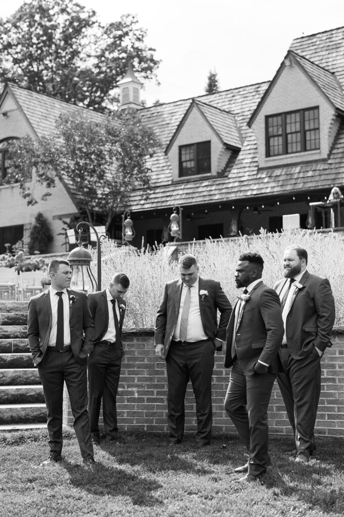 A b&w image of a groom and his groomsmen outside his northwest ohio barn wedding venue