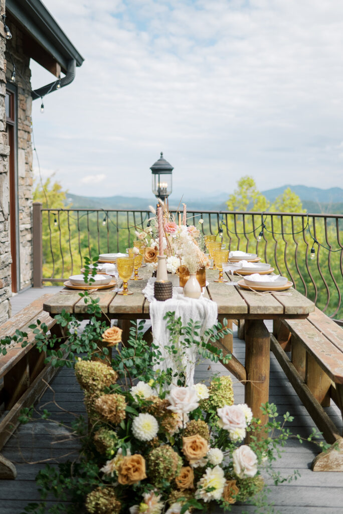 A scenic shot of a Cades Cove wedding reception featuring floral sprays and scenic views of the Smoky Mountains from the balcony of an Airbnb