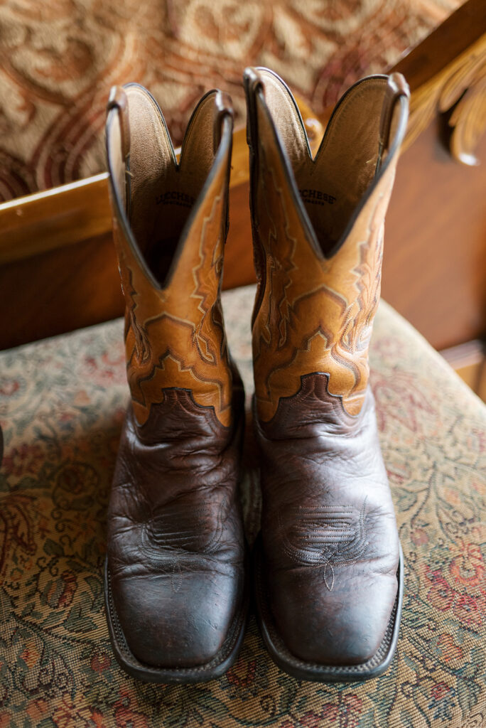 A detail shot of a groom's polished leather cowboy boots are photographed before his Cades Cove Wedding